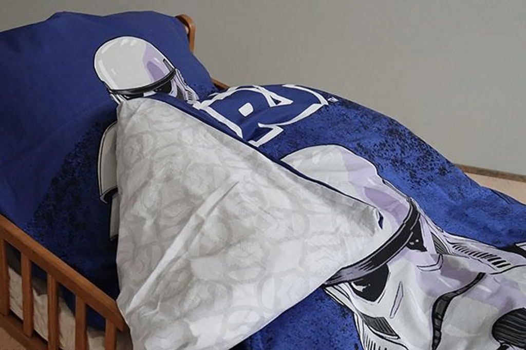 Ambiente Nahaufnahme vom Star Wars Stormtrooper Baby Bettwäsche Set 100x135 cm 100% Baumwolle in einem Bett mit umgeschlagener Rückseite vom Bettbezug